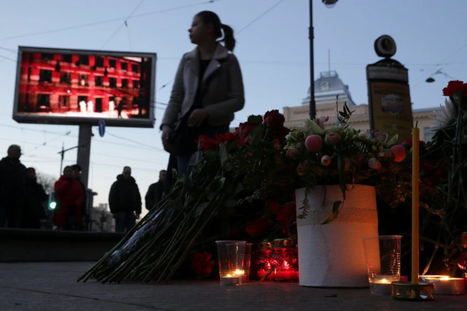 Люди несут к месту трагедии цветы и свечи