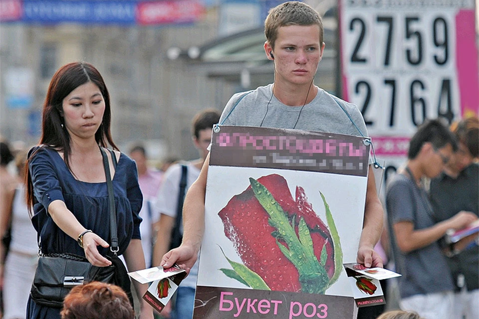 Промоутер раздает листовки на Пушкинской площади, Москва.