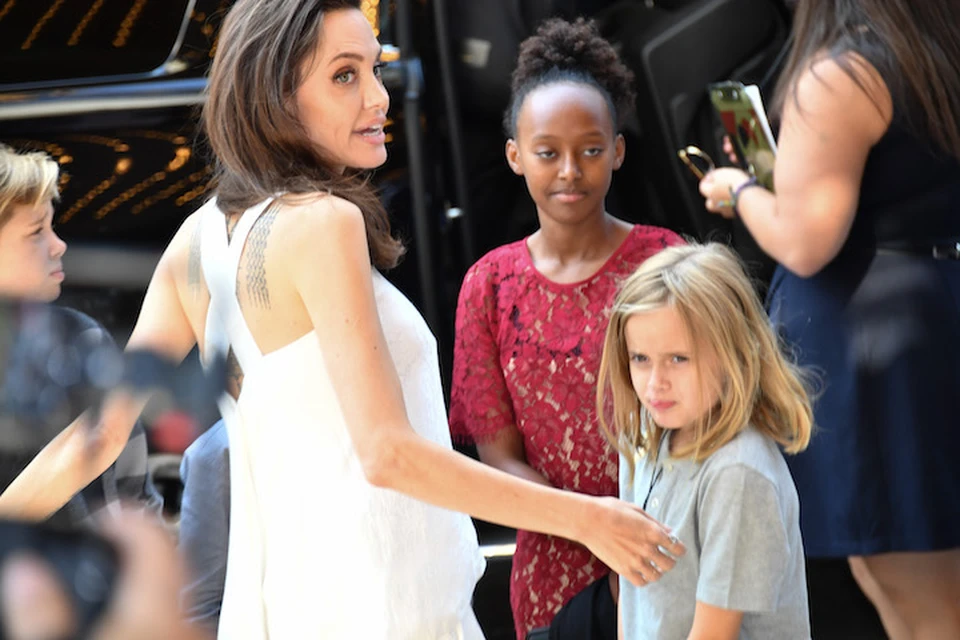 Анджелина Джоли вместе со всеми шестерыми детьми приехала на кинофестиваль в Торонто. На фото - с младшей дочкой Вивьен и средней Захарой.