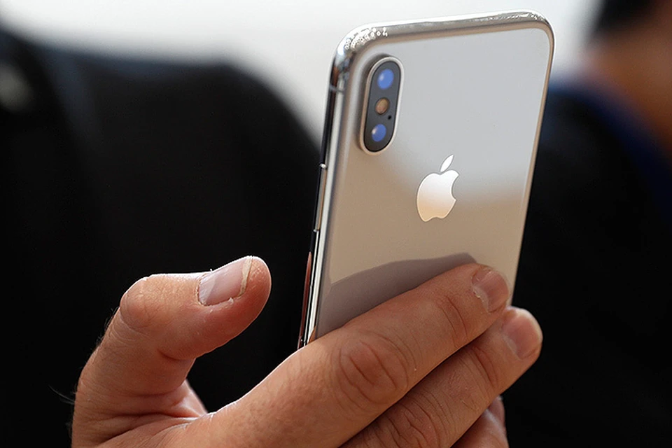 Посетитель презентации Apple держит в руках новинку - iPhone X.