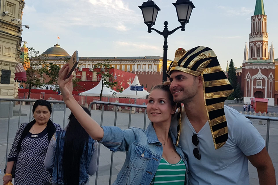 Туристы делают селфи на фоне заборов, которыми обнесли Красную площадь