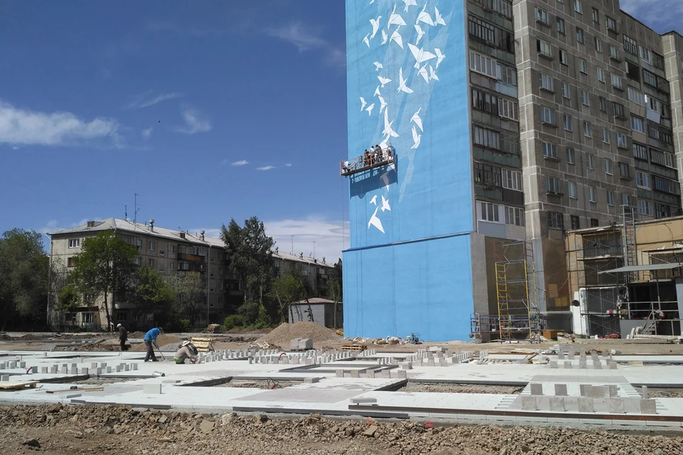 Художники Михаил Котлованов и Тимур Абдуллаев рисуют на фасаде гигантское граффити.