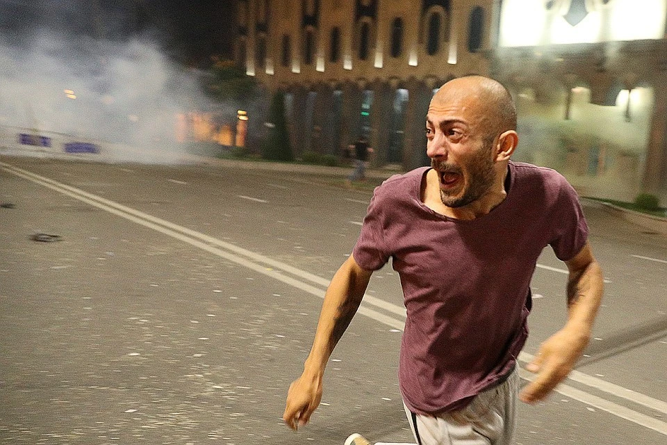 Участник уличных протестов у здания парламента в Тбилиси.