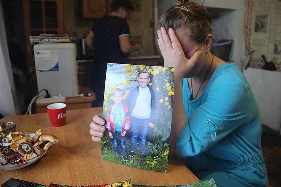 Людмила Кузьмина показывает фотографию сыновей, которые погибли по вине коммунальщиков год назад.