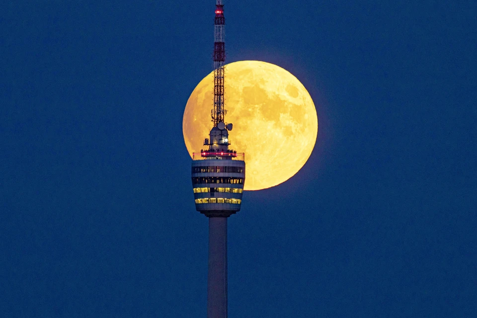 Луна на фоне телебашни в немецком Штутгарте.
