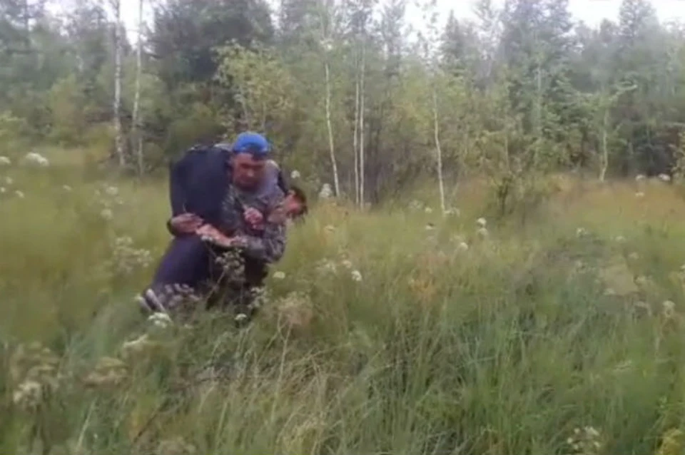 Спасатель вытащил сибирячку из болота. Фото: скриншот видео Республиканского агентства ГО и ЧС.