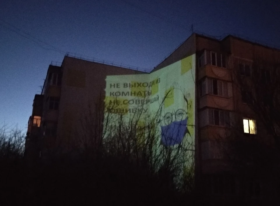Белгородский учитель проецирует картины с призывом «Сидите дома!» на стены многоэтажки. Фото из архива Никиты Шумакова.