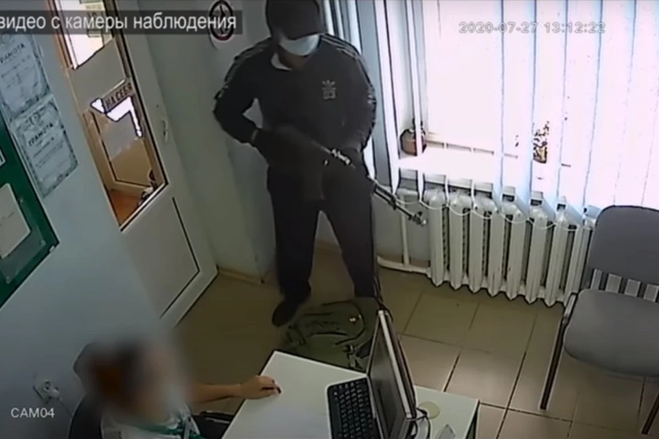 Грабитель был с автоматом в руках, лицо его скрывала медицинская маска. Фото: МВД ЛНР
