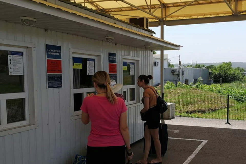 Украинские пограничники на КПВВ «Новотроицкое» проверяют предудущие въезды-выезды людей, которые проходят контроль. Фото ГПСУ