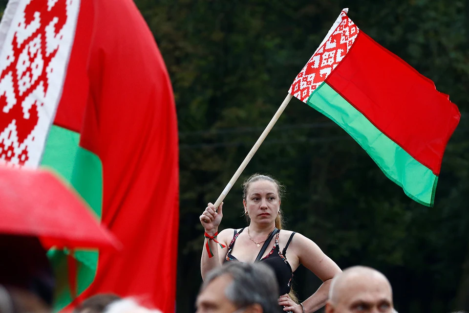 Участница митинга поддержки Александра Лукашенко с флагом.