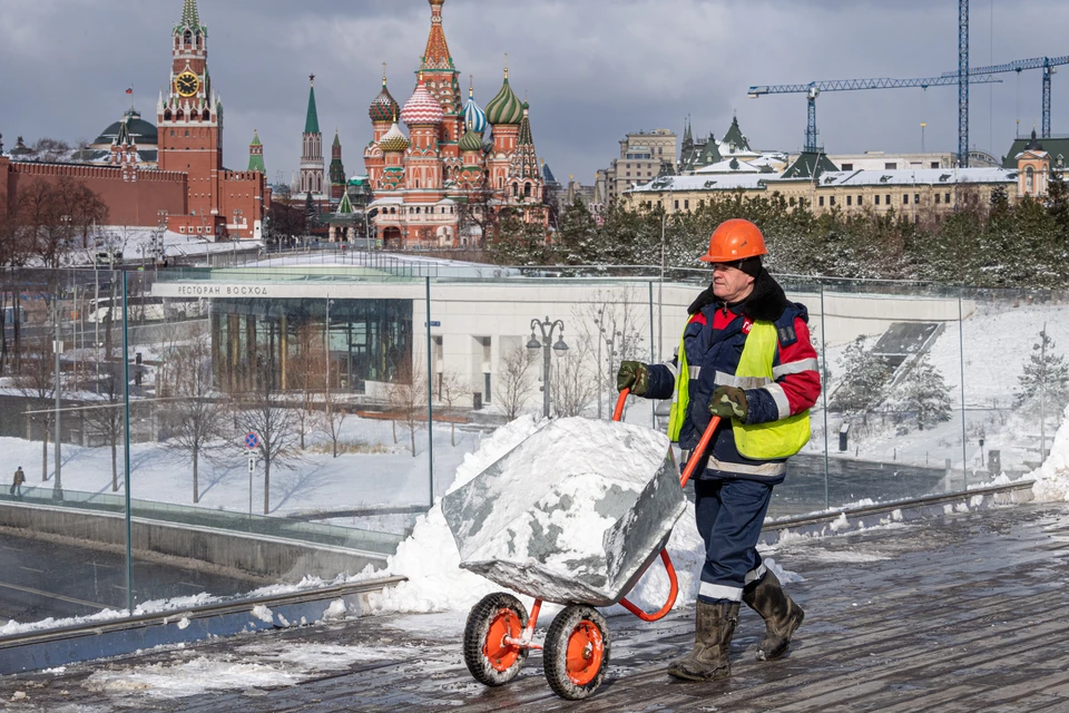 Сотрудник коммунальной службы во время уборки снега на Парящем мосту в парке `Зарядье`.