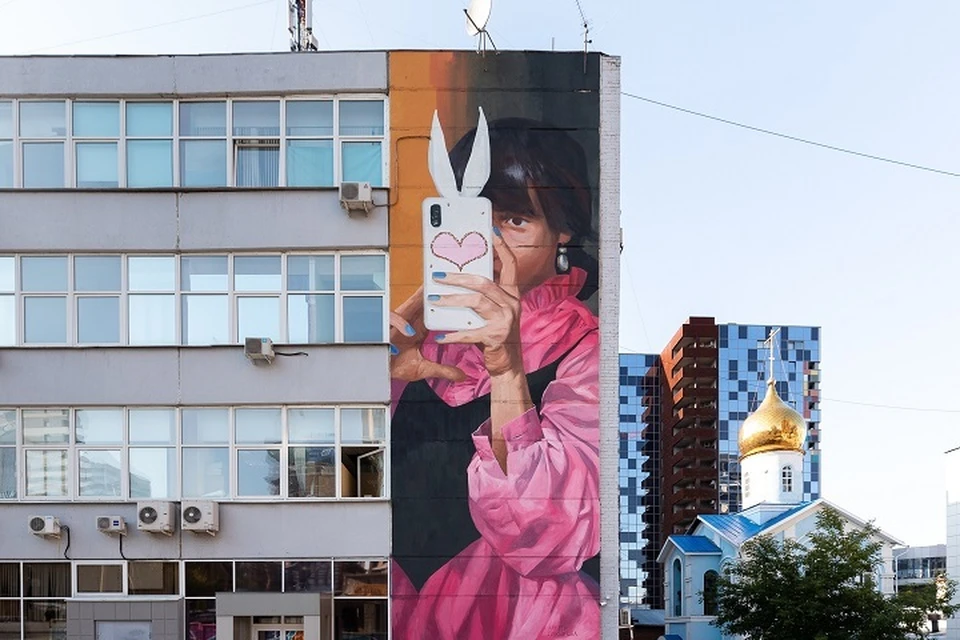 Анетта Лукьянова нарисовала стене офисного здания изображение девушки с телефоном. Фото: пресс-служба фестиваля «Стенограффия»