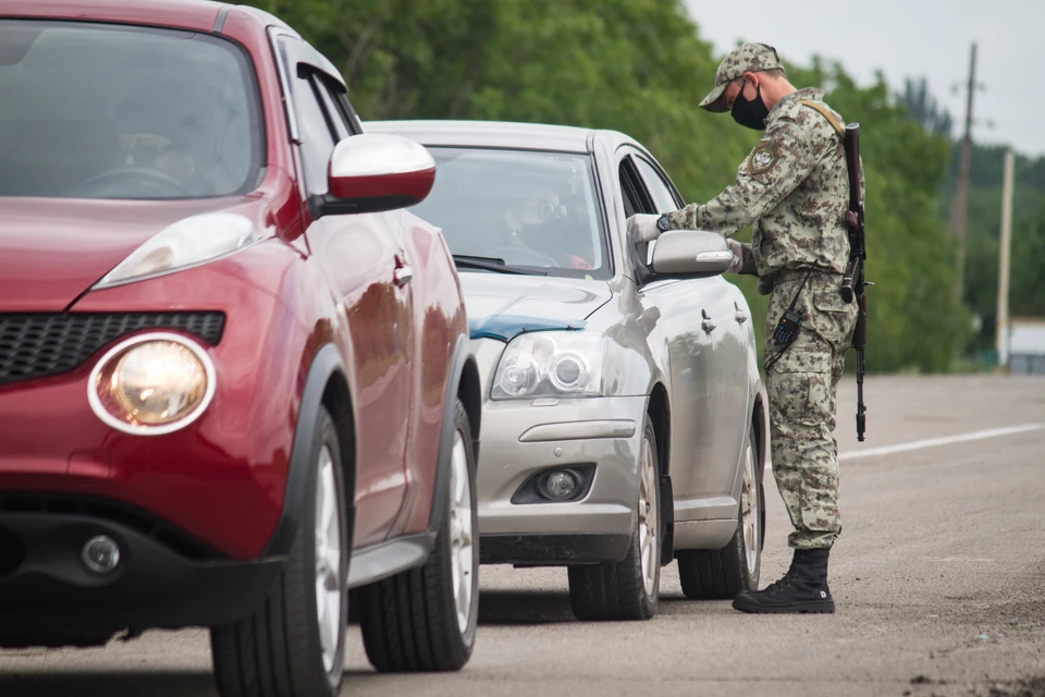 Боец сил обороны ДНР проверяет документы у водителя автомобиля, покидающего непризнанную республику.