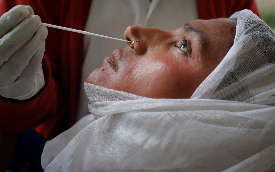 Взятие мазка на коронавирусную инфекцию у жительницы города Ахмадабад, Индия.