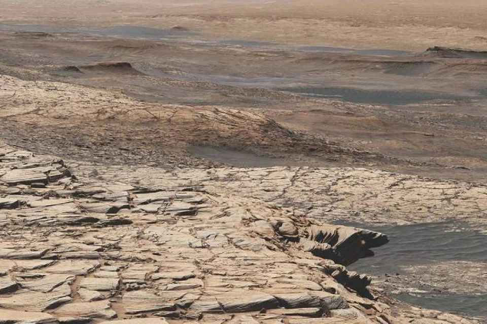 Марсианская поверхность, из-под которой "Любопытство" высверлил отложения, богатые изотопом углерода.