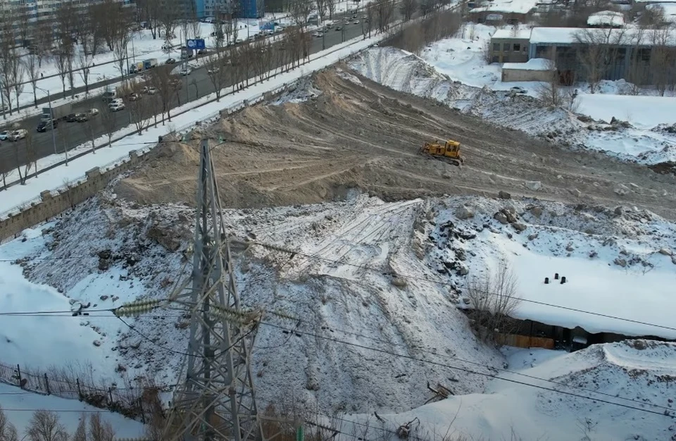 По площадке ездит одинокий трактор