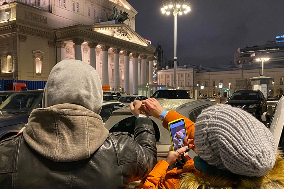 Желающие приобрести билет на "Щелкунчик" фотографируют бумажные браслеты в очереди.