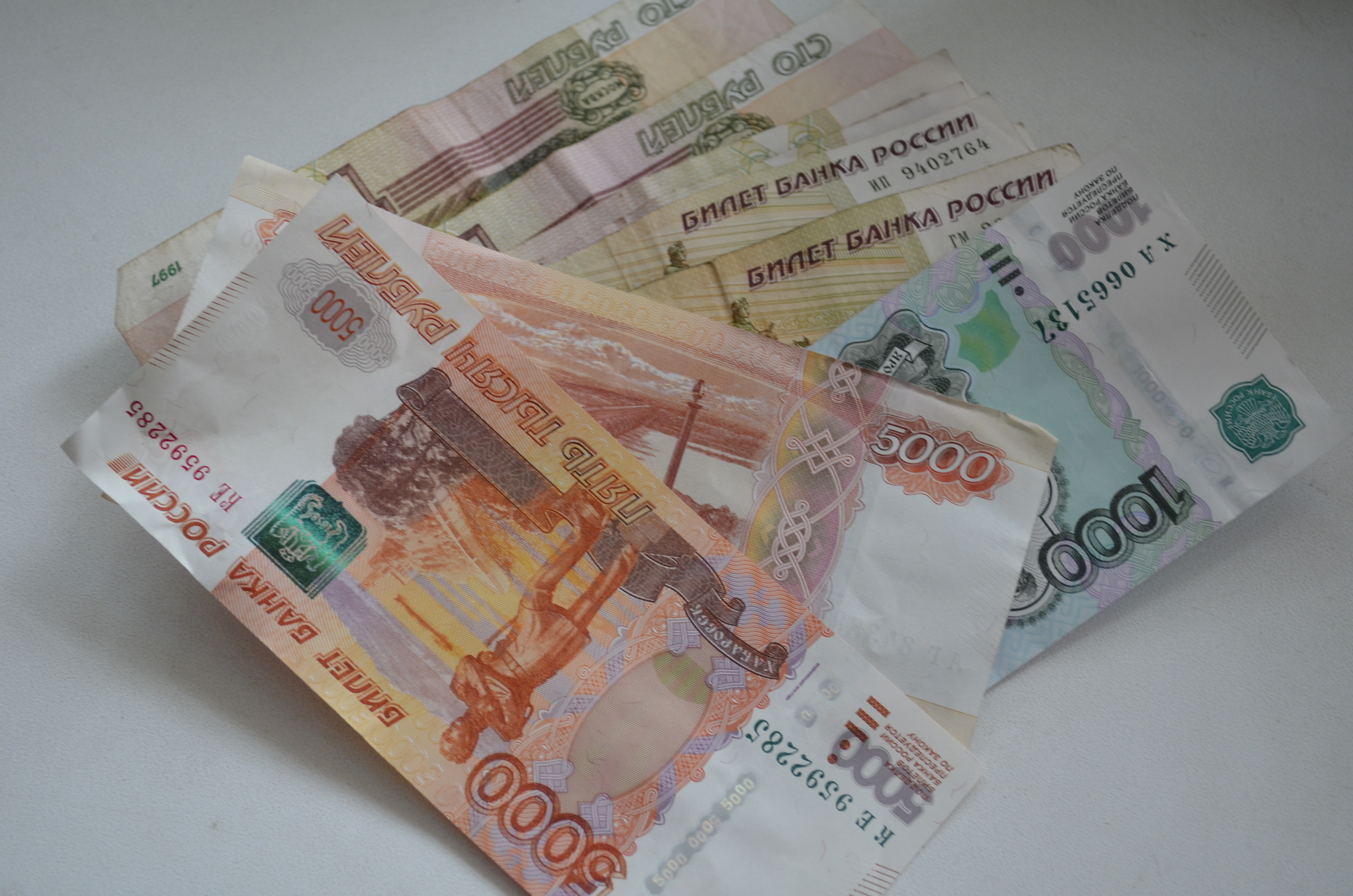 Выплата 5 000 рублей. Деньги разложенные на столе 2 тысячи рублей.