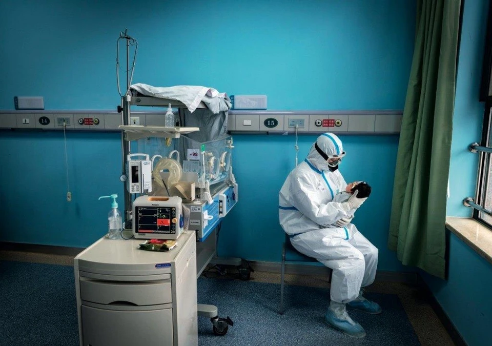16 марта 2020 г., г. Ухань пров. Хубэй, медсестра укачивает новорожденного в карантинном отделении больницы для заразившихся коронавирусной инфекцией. Фото Пань Сунгана.