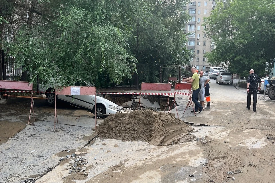 В Новосибирске машина, припаркованная у дома, провалилась в разрушенный асфальт. Фото: "АСТ-54".