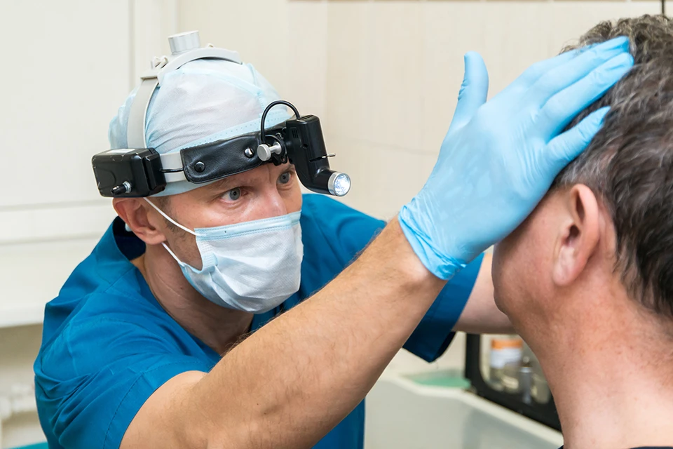 Дмитрий Сергеевич Алексеенко, заведующий оториноларингологическим отделением, проводит осмотр пациента после эндоскопической синус-операции. Фото: «РЖД-Медицина» Новосибирск»