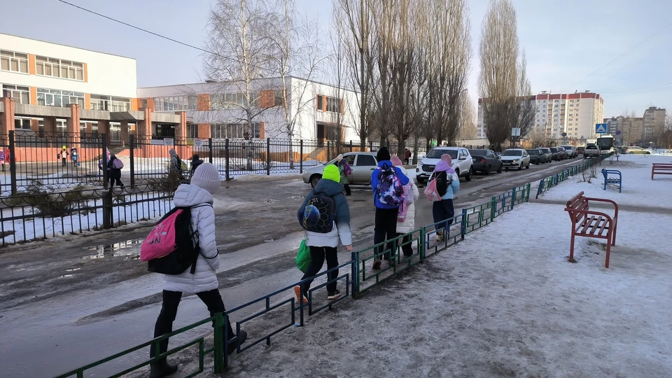 Дети идут в школу прямо по кромке дороги.