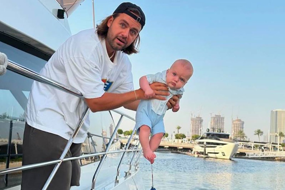 С пугающей улыбкой свесил младенца за борт яхты: Швырявший сына в сугроб блогер выложил новое провокационное фото