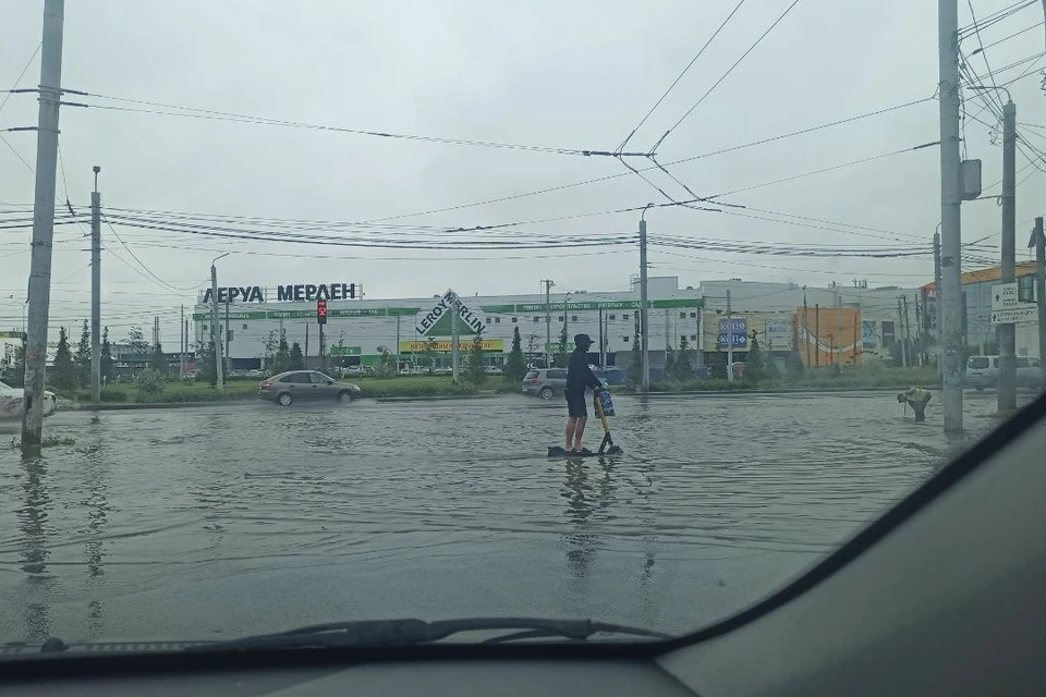 Самокатчики рассекают по воде, а коммунальщики пытаются почистить ливневки.