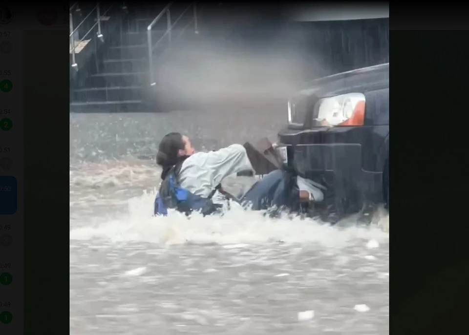 Девушек бурным потоком снесло под колеса авто. Фото: скрин с видео