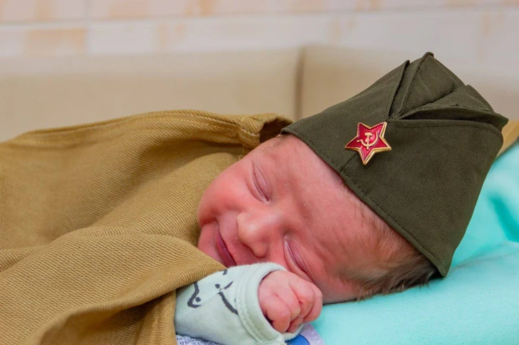«Патриотизм с пеленок»: в Кузбассе новорожденных одели в миниатюрные пилотки и плащ-палатки