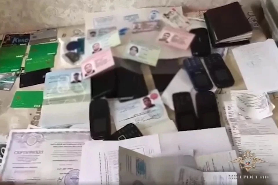 При обыске у фигурантов изъяли банковские карты, бланки миграционного учета, печати с оттисками миграционных служб