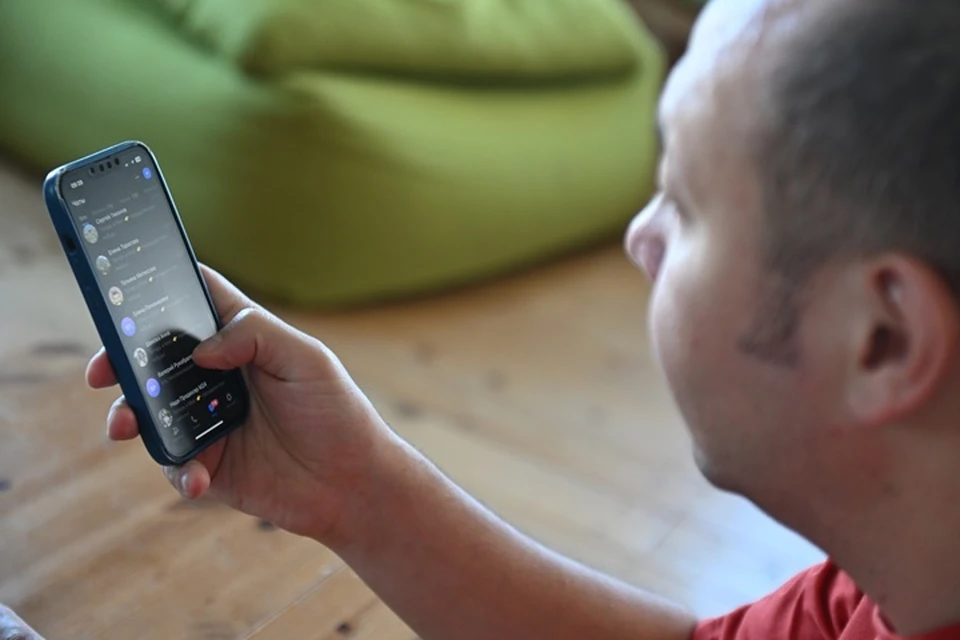 Обозреватель отдела Экономики "Комсомольской правды" Евгений Беляков просматривает список контактов в мессенджере Max на мобильном телефоне