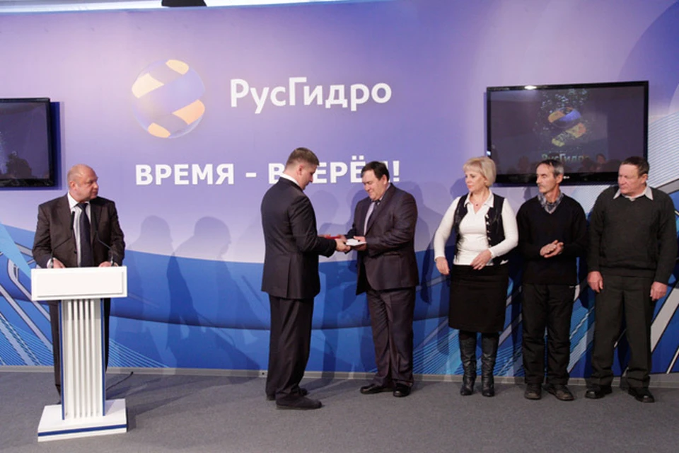Глава "РусГидро" Евгений Дод вручает награды ветеранам-гидростроителям.