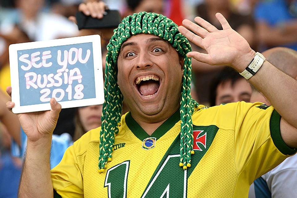 Бразильский болельщик держит планшет с надписью "Увидимся в России в 2018 г."
