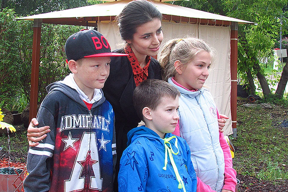 Мисс Россия фотографируется с детишками на память.