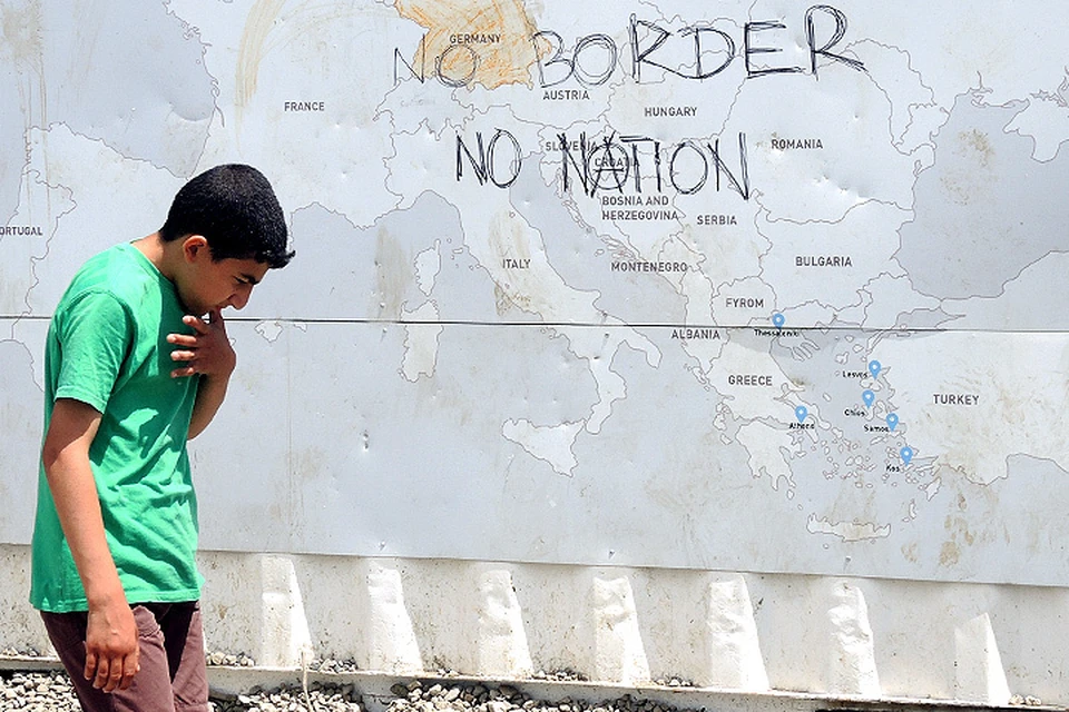 Беженец на фоне надписи "Нет границам! Нет нациям!"