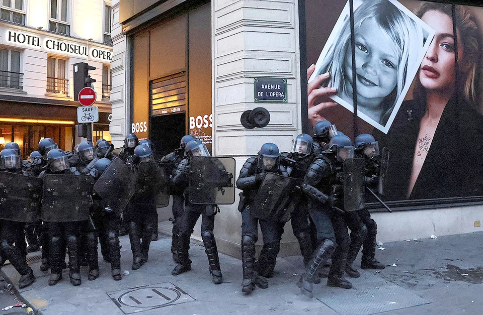 Полицейские выстроились у магазинов люксовых брендов в центре Парижа, где больше недели не утихают массовые протесты против пенсионной реформы правительства Макрона. Фото: REUTERS